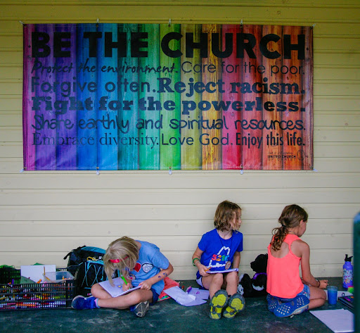 Children under a "Be the Church" sign